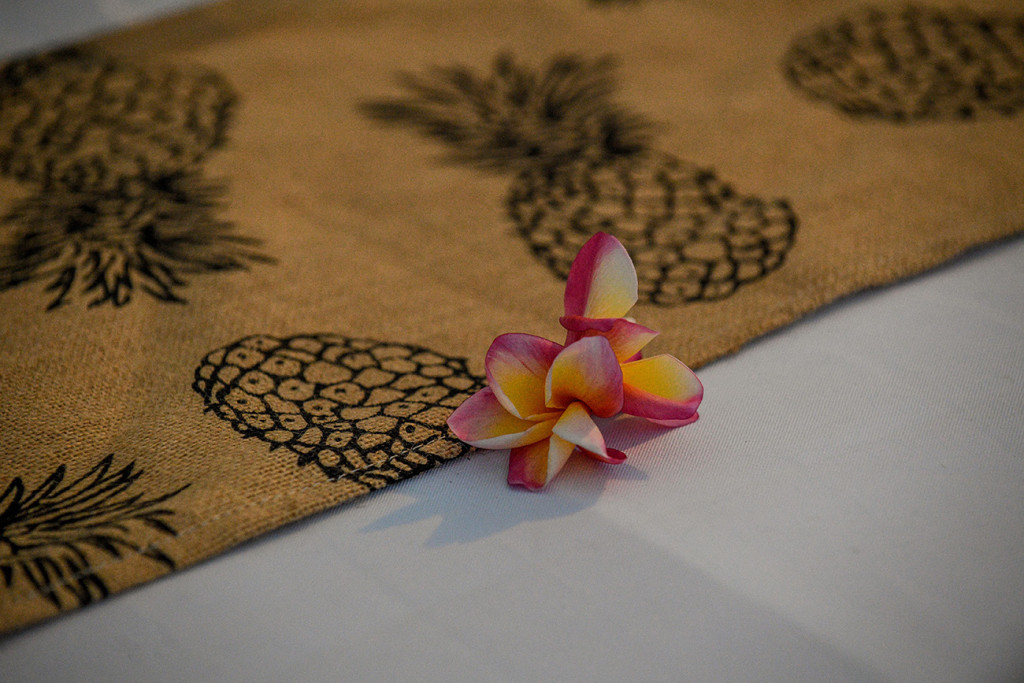 Closeup of colourful pink and yellow Fiji frangipani at wedding table decor