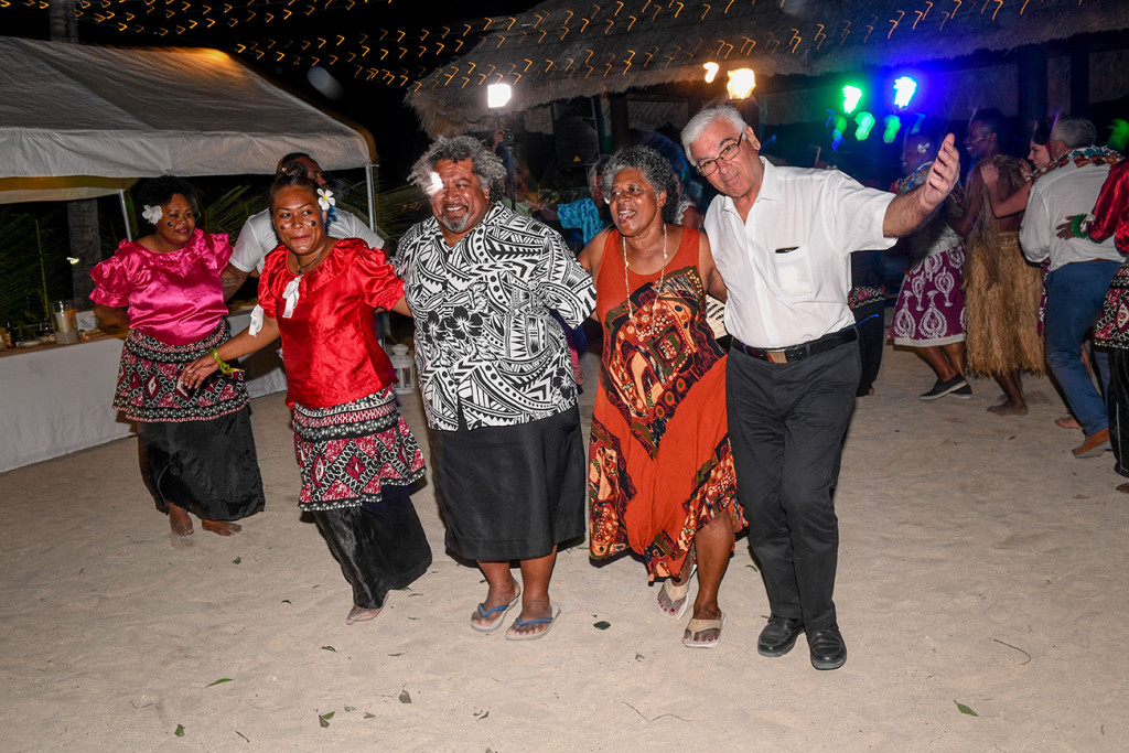 The bride's family joins the traditional performers for a dance on the beach