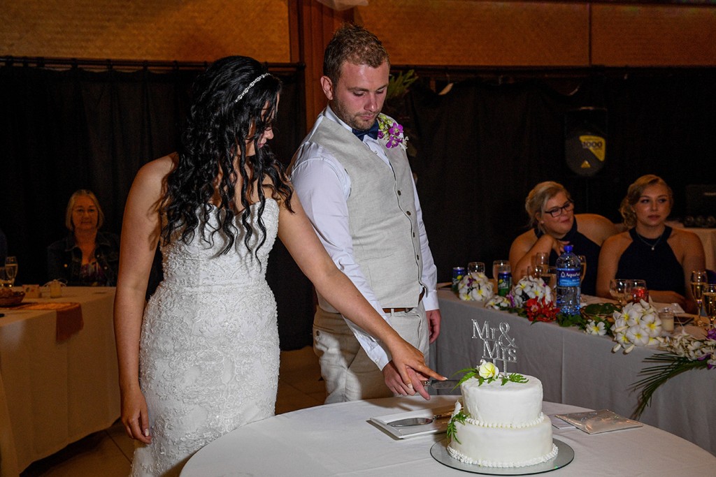 The newly weds cut their wedding cake together