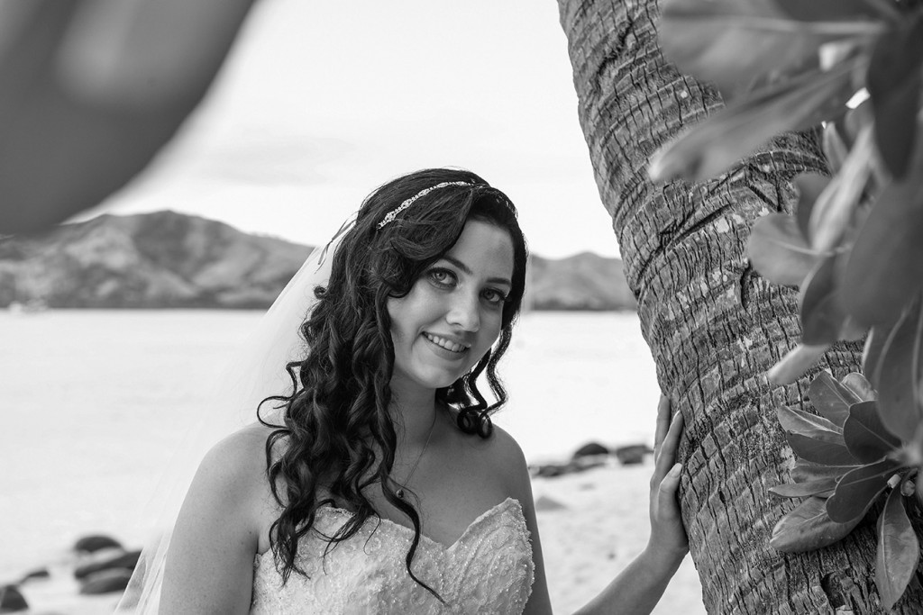 A stunning monochrome image of the bride next to a palm tree