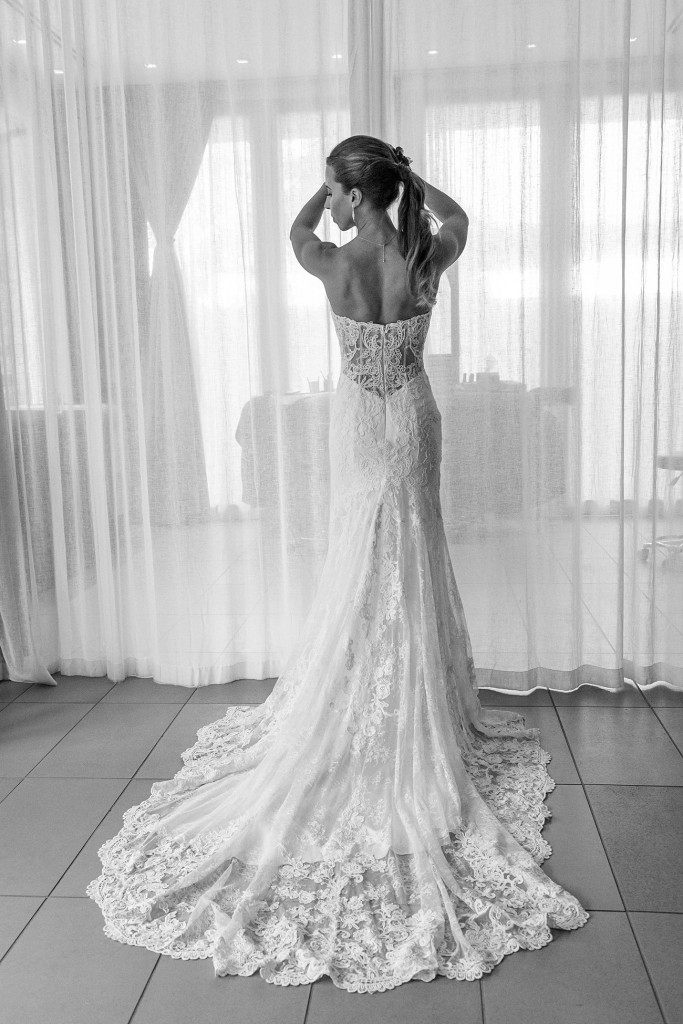 A monochrome full length image of the dressed bride