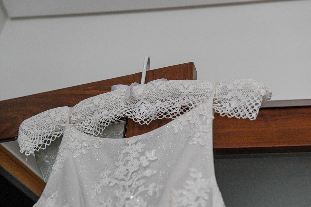 Glitter and lace adorn the torso of the brilliant white wedding gown