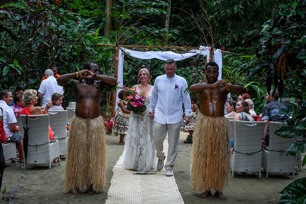 The newly weds walk down the aisle led by traditional Fiji warriors