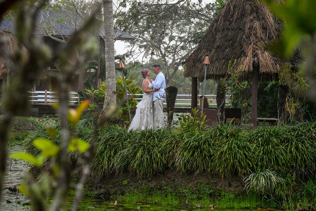 The couple embraces between traditional huts at Koro Sun