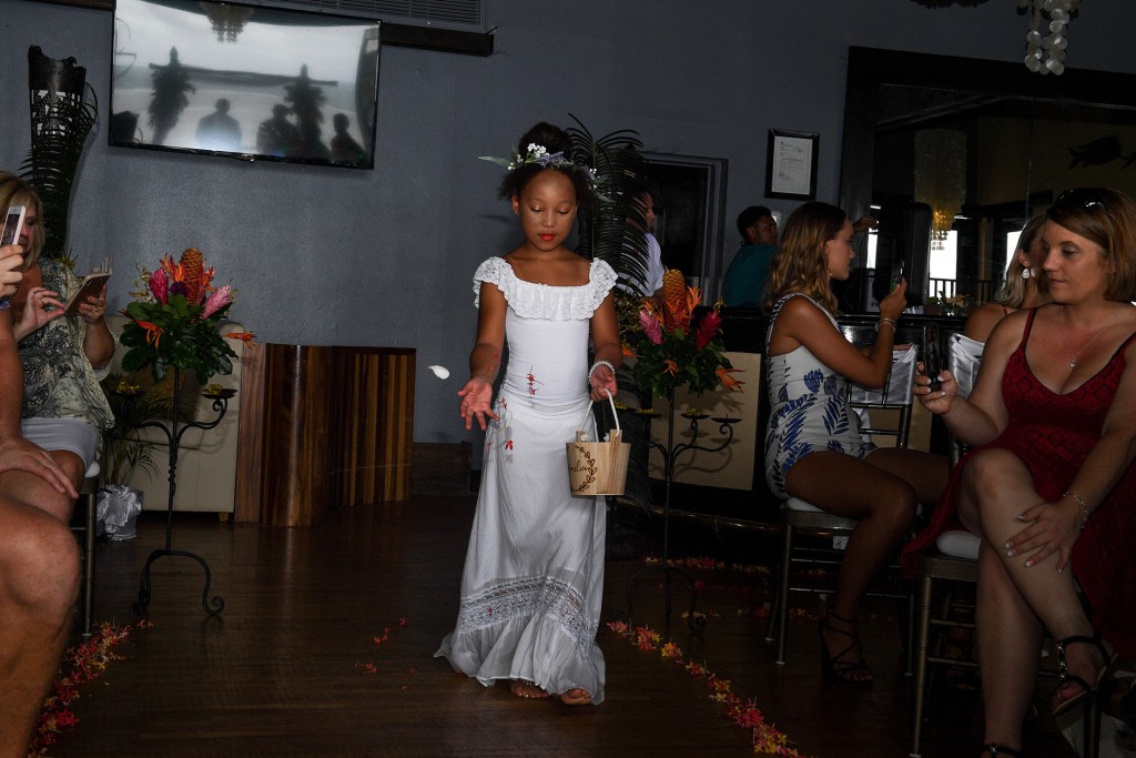 A beautiful Fiji flower girl scatters flowers down the aisle