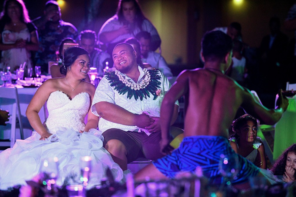 The newly weds reflect in their love as they watch traditional Fiji dancers entertain them