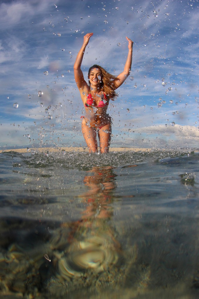 The model throws water at the camera lens