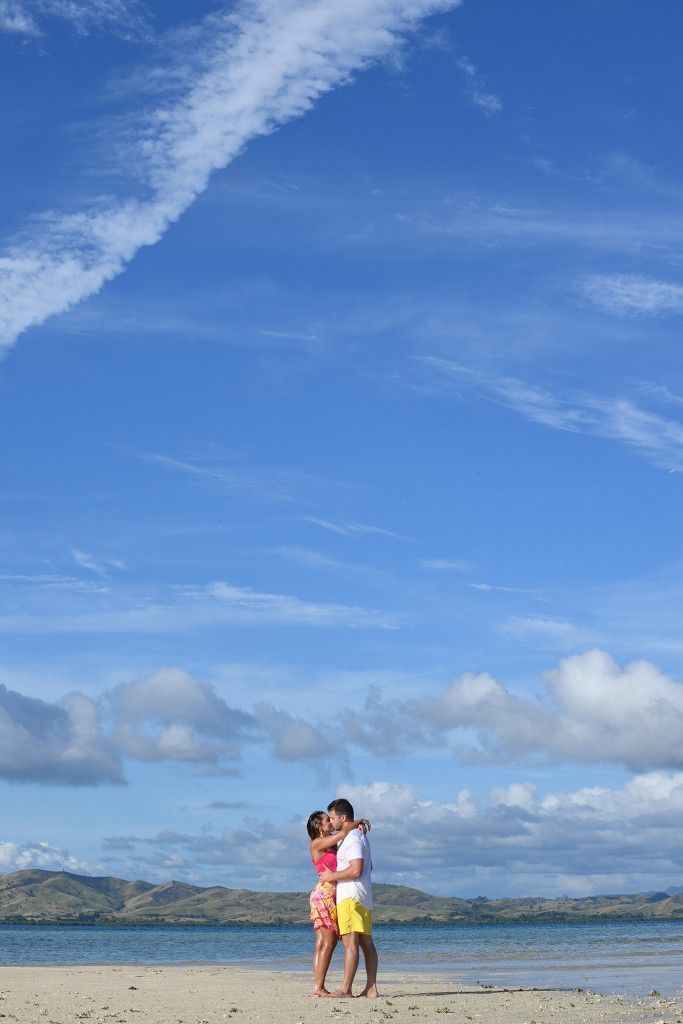The couple passionately kiss against the deep blue skies of Nadi Fiji