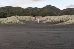 An out of focus image of the couple standing in black sand