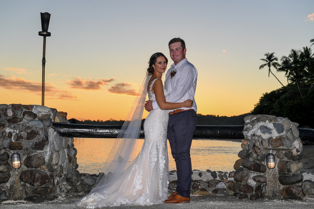 A full frame wedding portrait of the newly weds at sunset