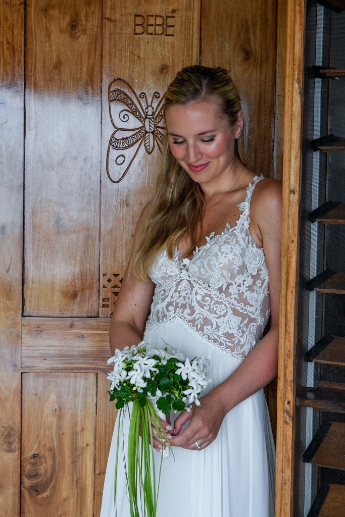 The bride poses in front of the butterfly door at Tropica Island Resort