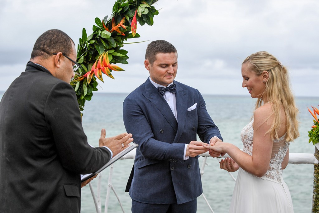 The groom slips the ring onto the bride's finger
