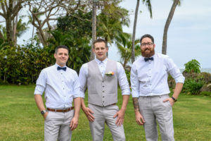 The groom and his groomsmen strike a pose with tall palm trees in the background