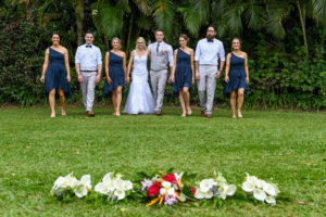 The newly weds pose with their bridal party with palm trees in the background