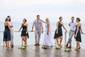 The bridal party and the newly weds hang out on a dock
