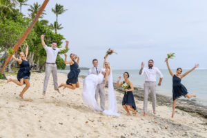 The newly weds celebrate on the beach with their bridal party