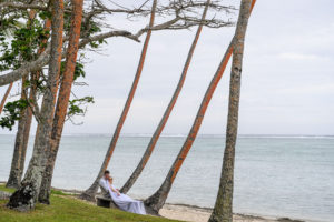 The newly weds cuddle against the towering palms of Shangri La Fiji
