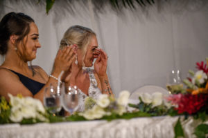 The bride wipes a tear as she listens to the wedding speeches