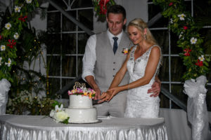 The bride and groom slice through their wedding cake