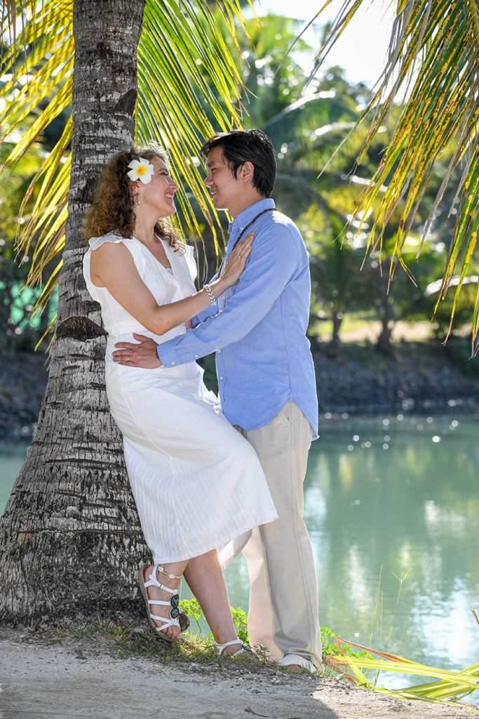 The loving couple embrace against a palm tree