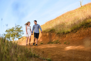 Frontal view of the engaged couple on the dirt-road in Summer Country Engagement photo shoot Pukekokhe Auckland Photographer Anais Chaine