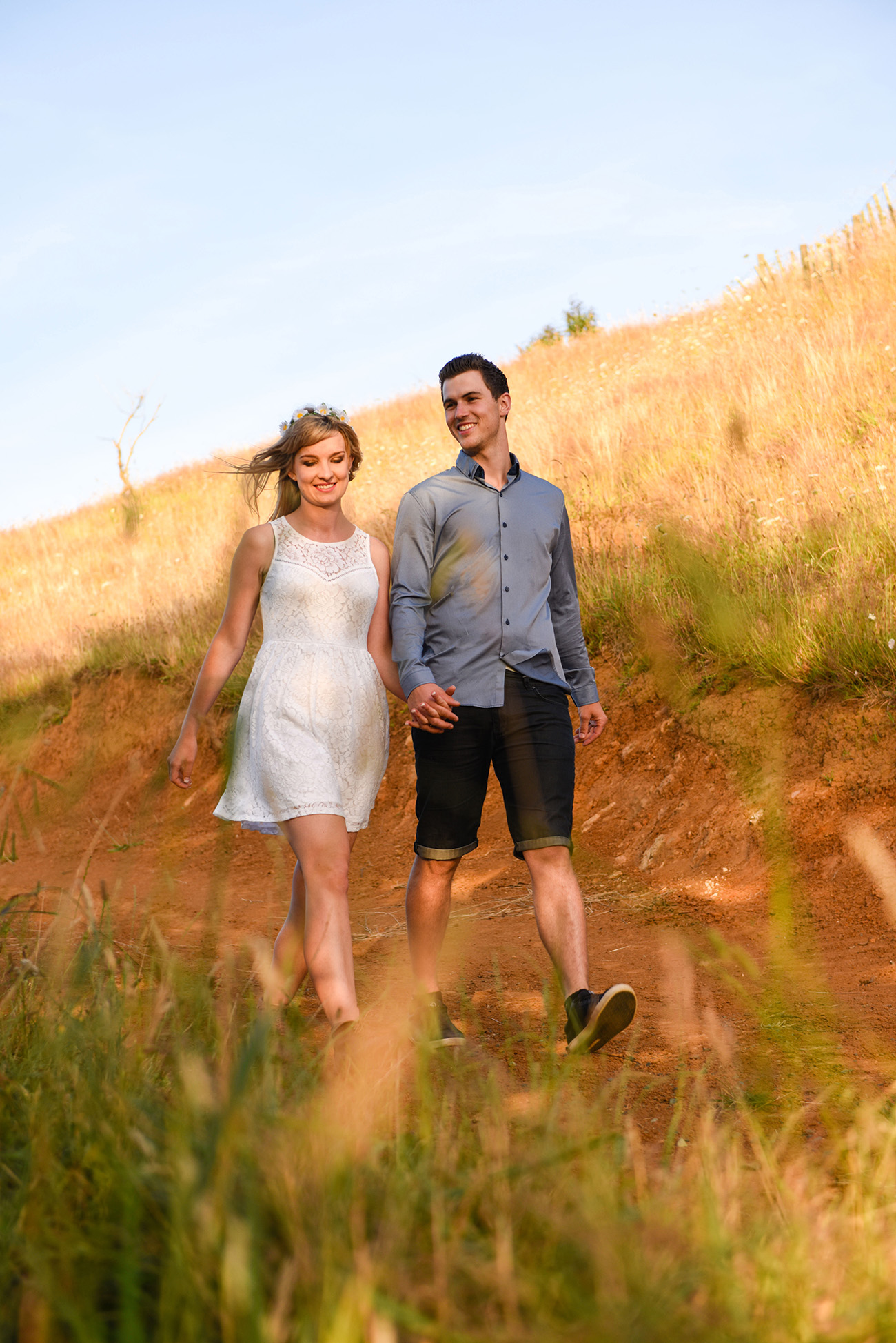 A frontal view of the engaged couple hand-in-hand Summer Country Engagement photo shoot Pukekokhe Auckland Photographer Anais Chaine