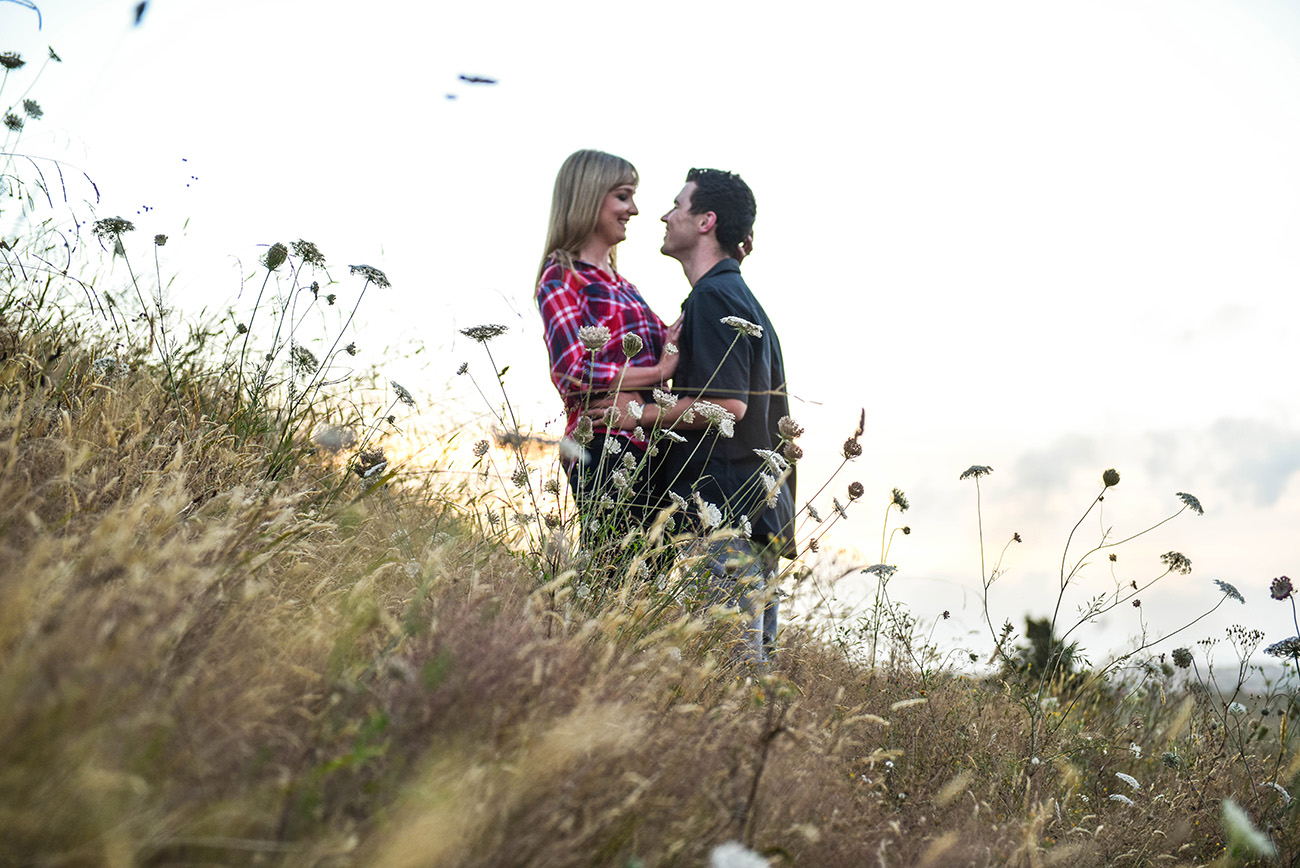 The couple laughing together in the high grass