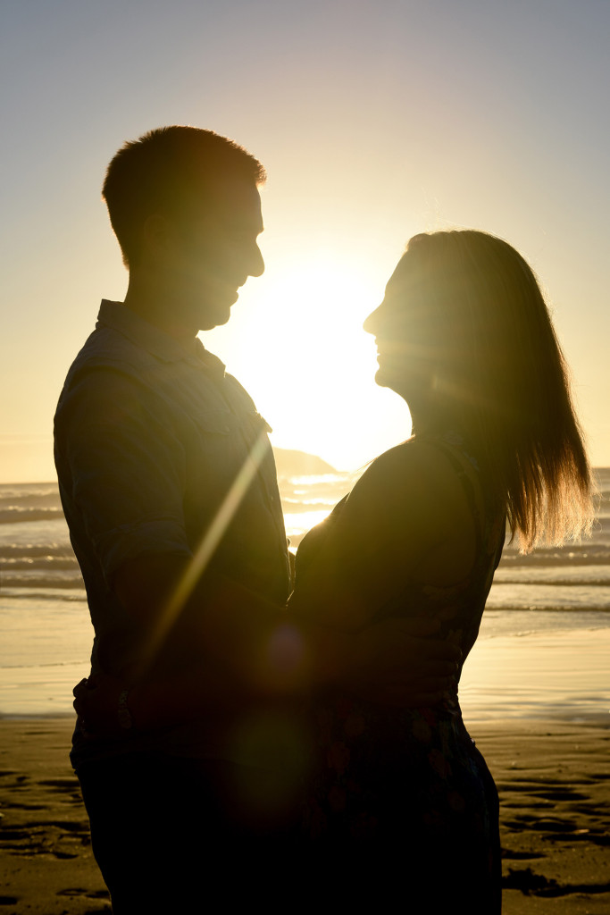 couple silhouette with sun and sea behind