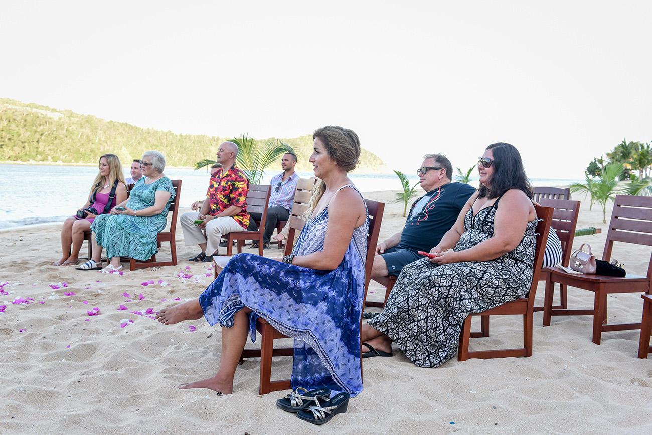 The guests are sited on wooden chairs by the beach At Paradise Cove Island resort in the Yasawas, Fiji