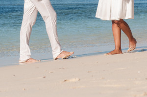 Legs of the couple walking on the white sandy beach at Mana Island resort, Fiji by Anais Photography