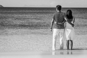 Couple looking at the sea feet in the sea black and white photograph at Mana Island resort, Fiji by Anais Photography