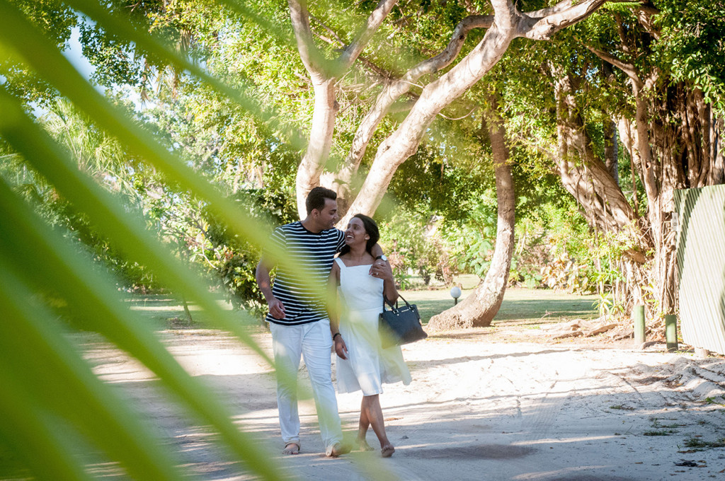 Couple walking together through a palm tree leaf at Mana Island resort, Fiji by Anais Photography