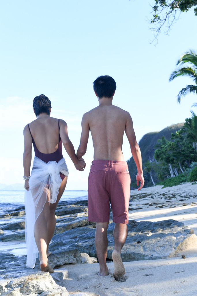 couple holding hands wearing swimwear at Tokoriki island resort in Fiji photographed by Anais Photography