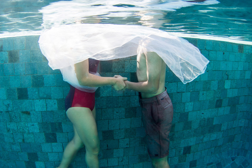 underwater couple holding hands in the swimming pool at Tokoriki island resort in Fiji photographed by Anais Photography