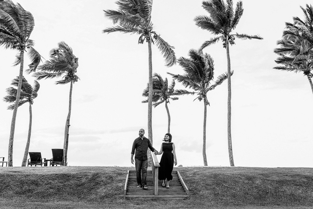 Couple holding hand walking down the stairs by the beack with palm trees at the Westin Resort in Denerau Fiji