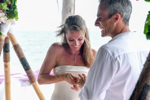 The wife is trying to put the wedding ring on her husband's finger at Vomo Island resort, Fiji