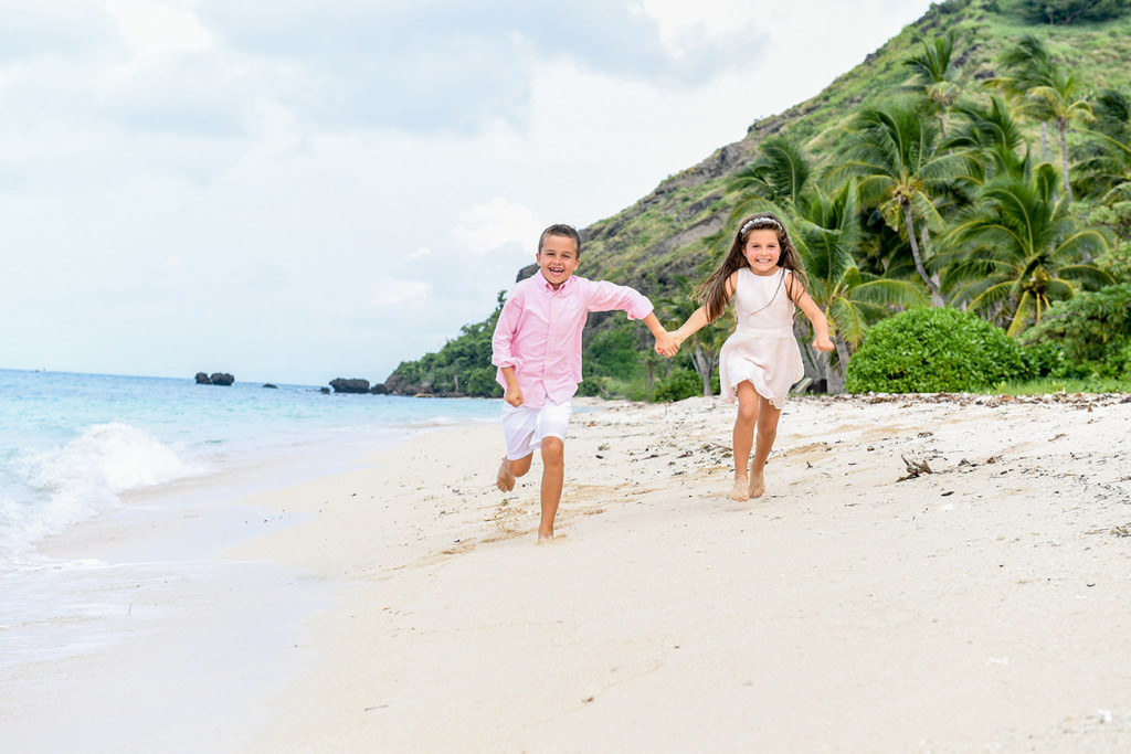 Brother and sister are running along the beach at Vomo Island resort, Fiji