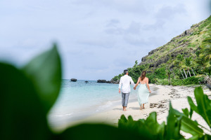 Couple walking along the beach at Vomo Island resort, Fiji