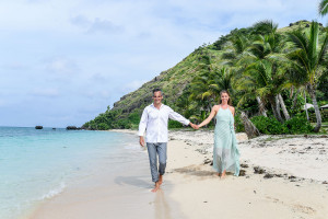 Couple walking along the beach and holding hands for their 10 years wedding anniversary at Vomo Island resort, Fiji