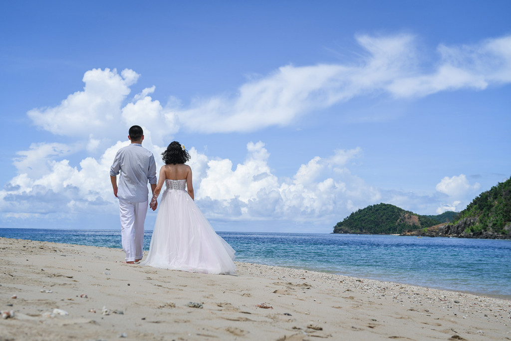 Bride and groom walking along the beach at Paradise Cove island resort, Fiji