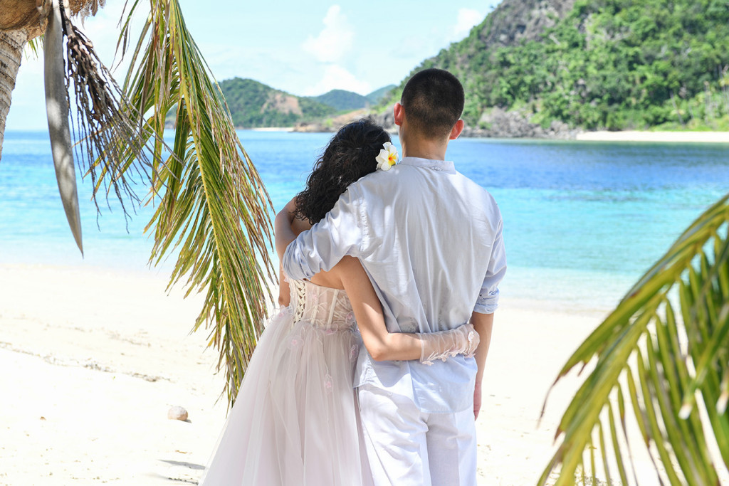 Back of bride and groom watching at the sea Paradise Cove island resort, Fiji