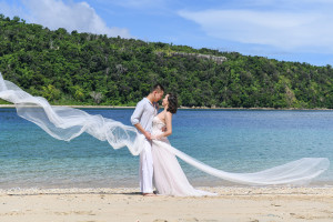the bride and groom are holding eachothers while the veil is falling around them Paradise Cove island resort, Fiji