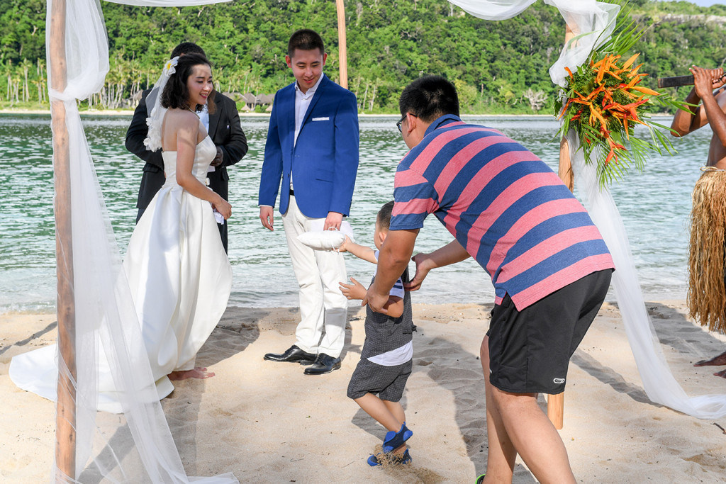 The little boy is bringing the rings to the bride and groom at Paradise cove island resort, Yasawas, Fiji