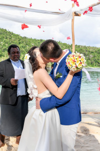 The bride and groom are kissing and the petals are thrown at them at Paradise cove island resort, Yasawas, Fiji