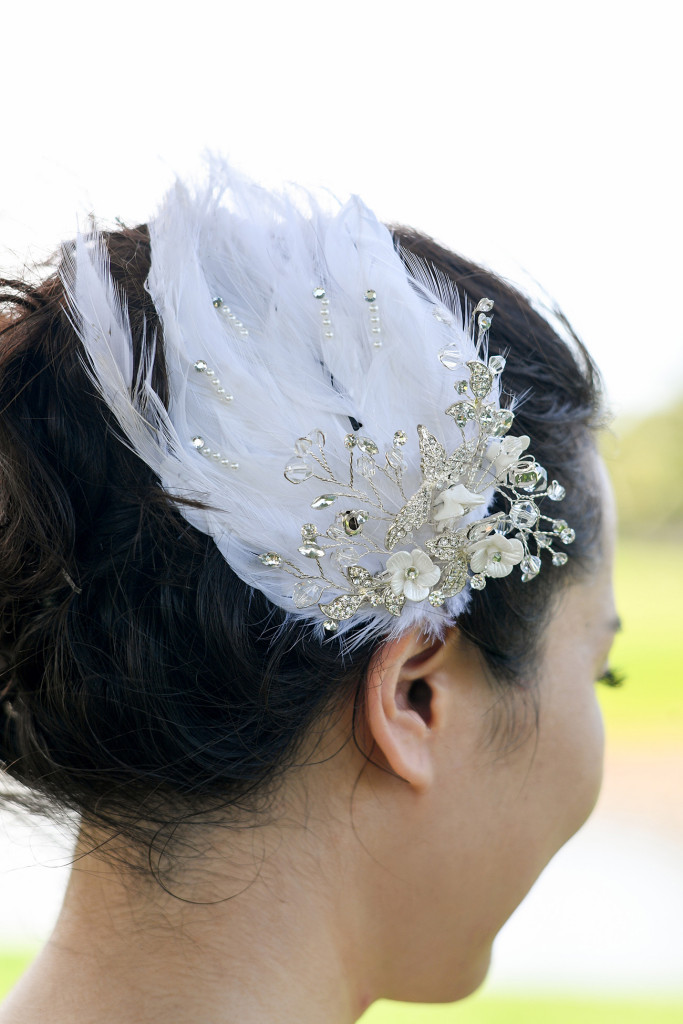 Detail of the hair piece of the bride made of white feathers and pearls