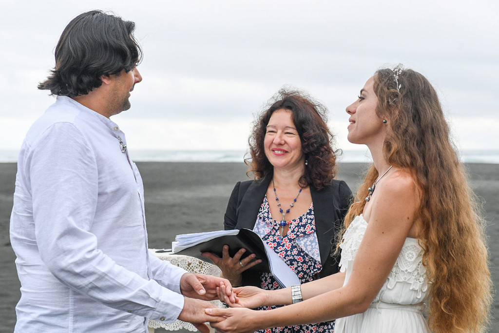 Eloped couple at altar of their black sand beach at Karekare Auckland New Zealand