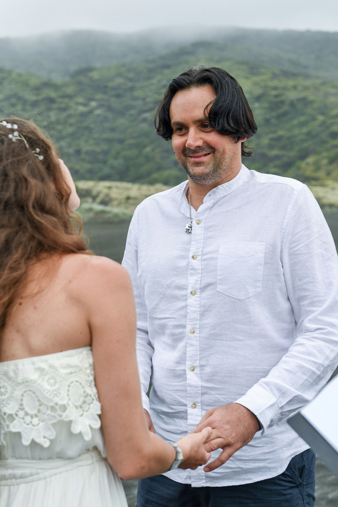 Eloped couple exchanging vows at the black sand beach of Karekare Auckland New Zealand