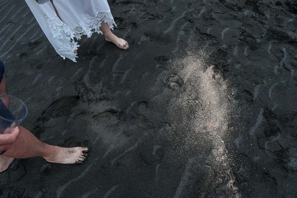 Newly eloped couple walk on Black sand beaches of Karekare Auckland NZ
