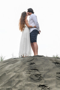 Eloped couple share a moment on a hill on black sand beach of Karekare Auckland NZ