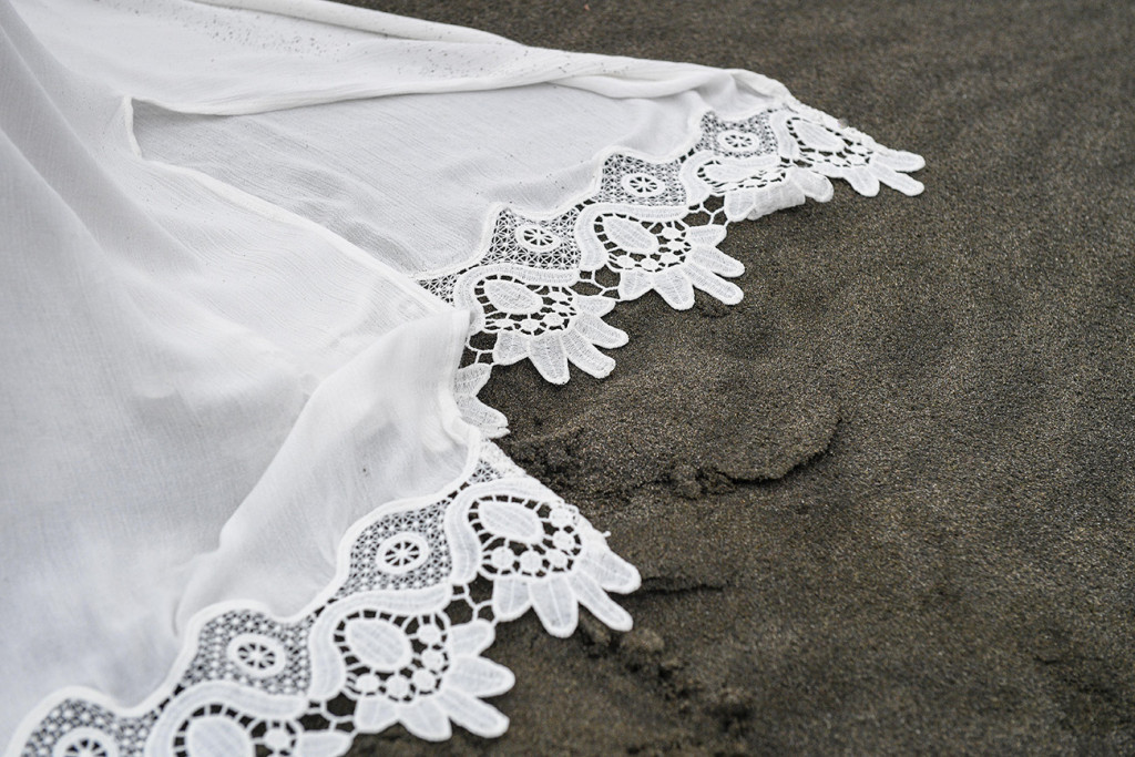Lace detail on the bride's gown on the shores of Karekare Beach, Auckland NZ